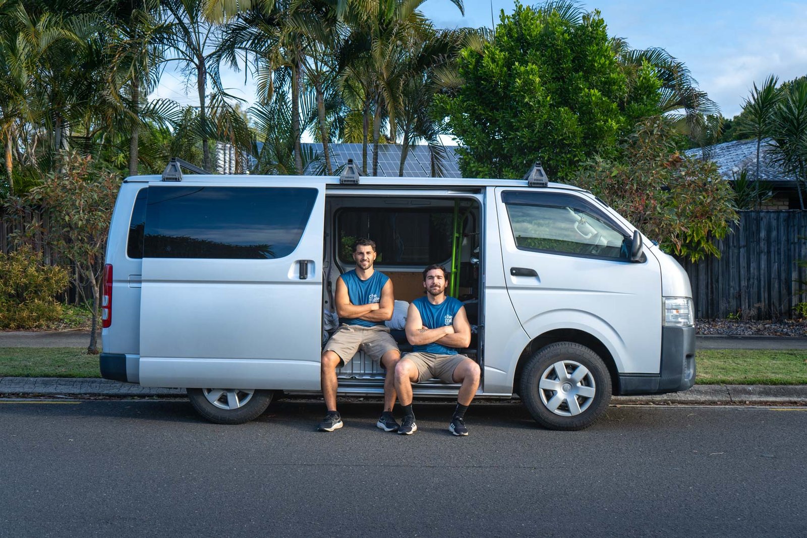 The two Che Mate owners sitting in the back of their van, arms crossed, smiling
